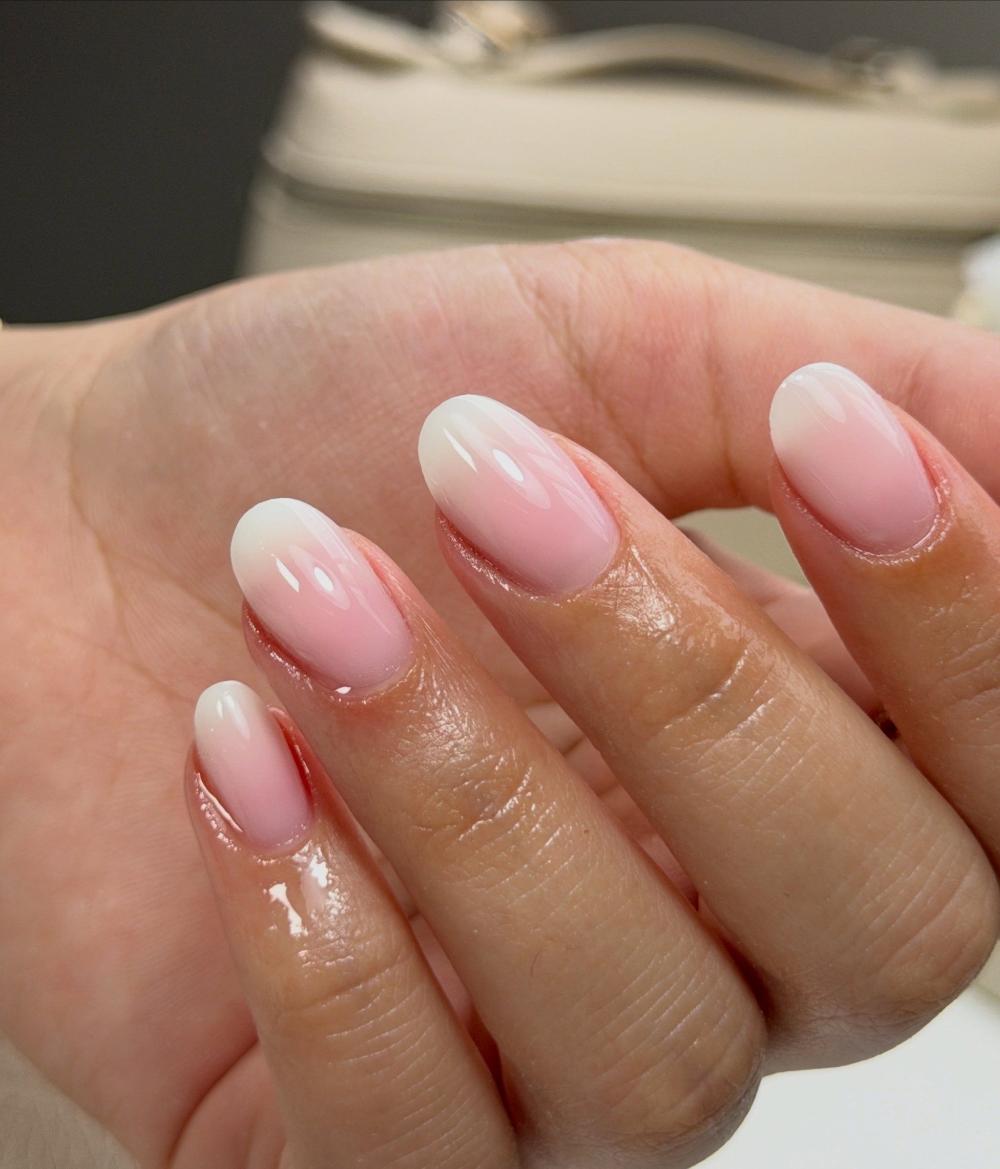 Natuurlijke nagels met BIAB in zacht roze, close-up van twee handen